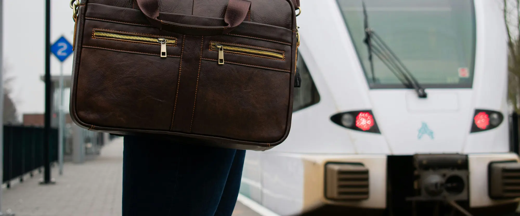Business traveller with a leather briefcase on a train platform