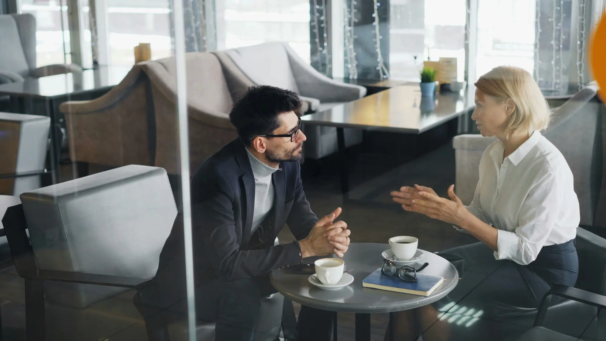 Advisor in conversation with a client over coffee